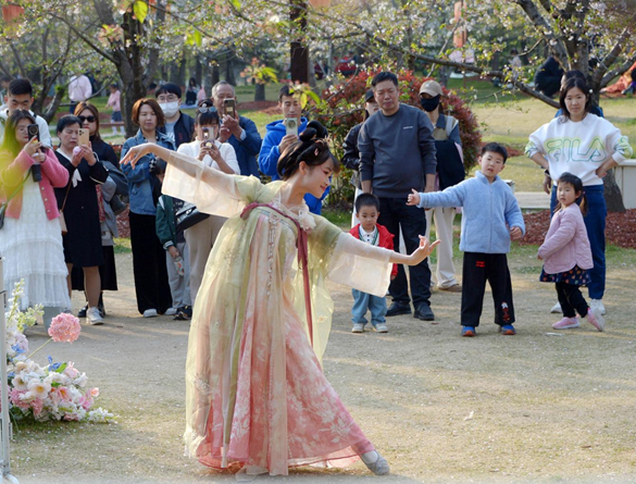 清明假期期間，上海顧村公園櫻花島上，游客在觀賞國(guó)風(fēng)漢服快閃表演。（圖片來(lái)源：視覺(jué)中國(guó)）