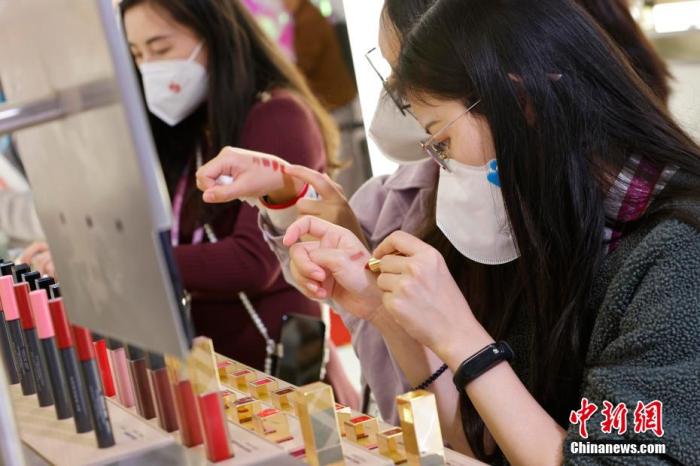 圖為女生正在體驗(yàn)口紅產(chǎn)品。 殷立勤 攝