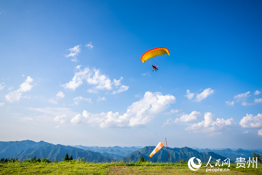 游客在野玉海飛行營地乘動力滑翔傘體驗(yàn)云端觀景。人民網(wǎng)記者 涂敏攝
