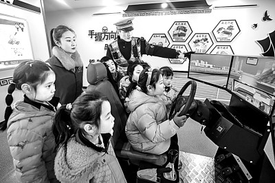 山東省榮成市公安局道路交通安全宣傳教育基地，交警帶領(lǐng)小學(xué)生現(xiàn)場體驗?zāi)M駕駛。新華社發(fā)