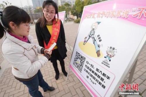 資料圖：今年3月8日，安徽合肥新華社區(qū)志愿者夏一瓊(右)向市民普及反家暴相關法律知識。鐘欣 攝