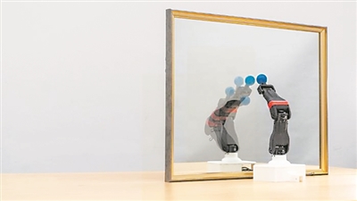 圖為機器人觀察自己在鏡子中的倒影,學習自身的形態(tài)和運動學,實現(xiàn)自主模擬。圖片來源:美國哥倫比亞大學